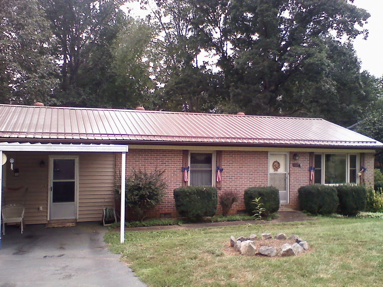 Bronze metal roof and carport on a brick ranch home — Roof Repair work by our crew in Cherry Valley